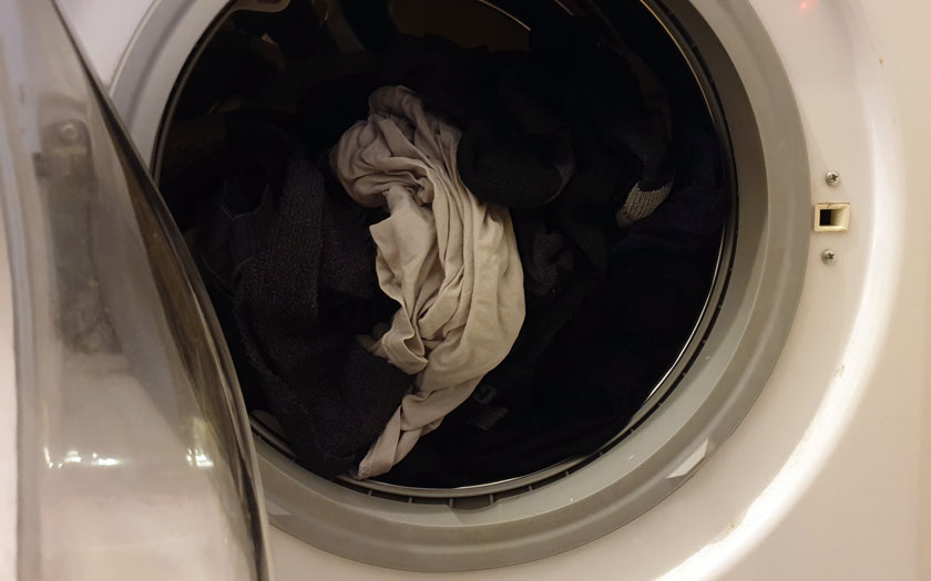 offene Waschmaschinentrommel mit nasser Kleidung